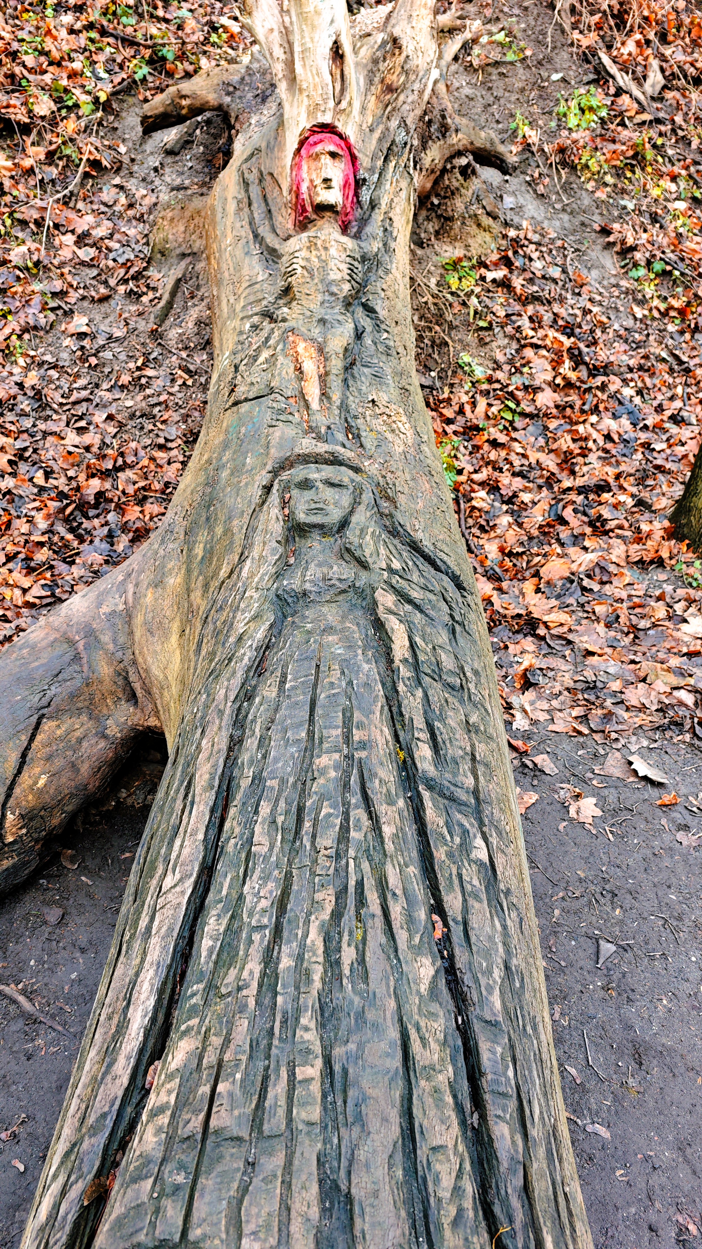 Tronco tallado con la imagen de jesucristo crucificado y la virgen María en el sendero fluvial a orillas del río Vilnelė, en Vilna.