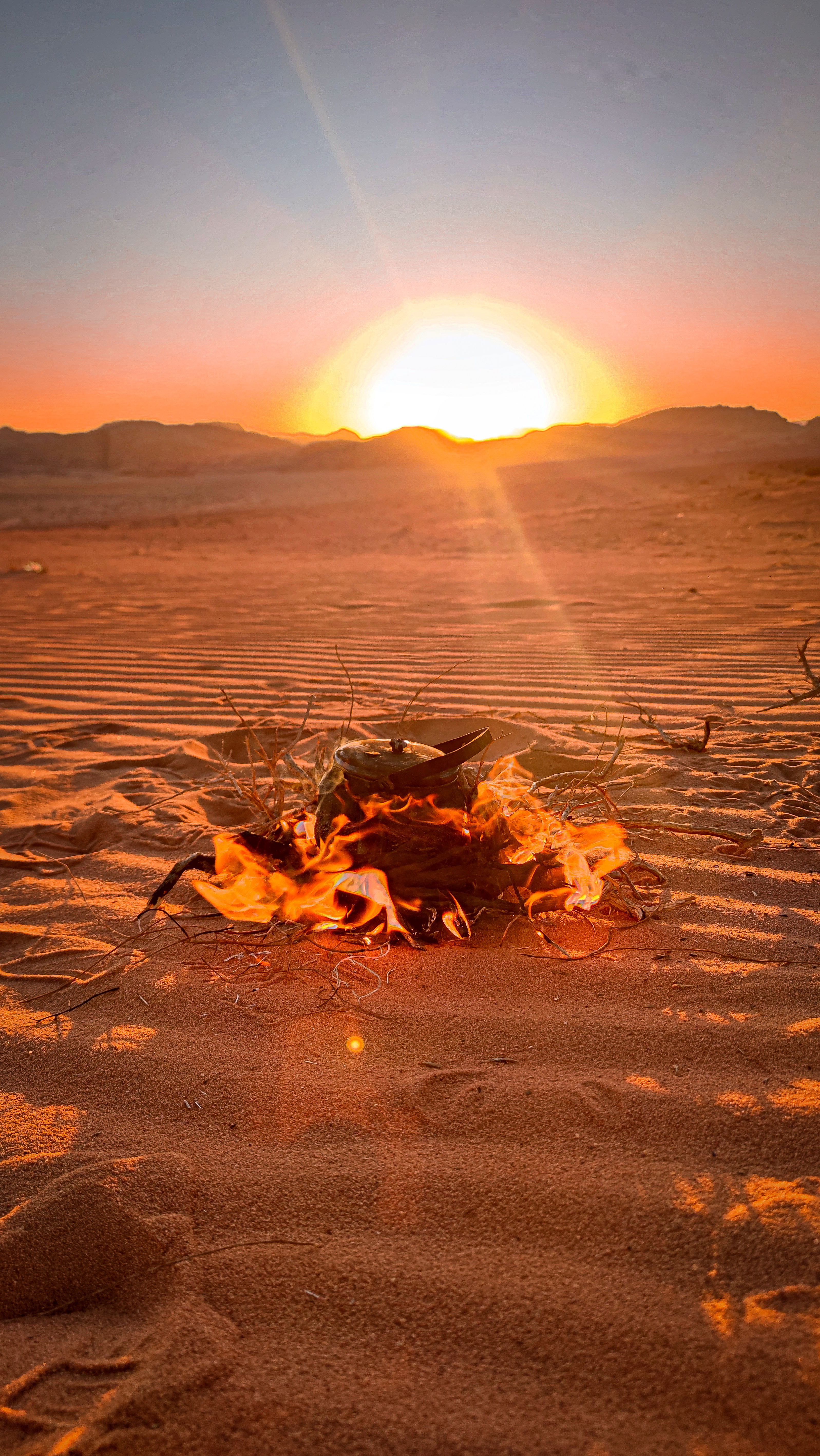 Hoguera y tetera al atardecer en el Desierto Blanco de Wadi Rum, Jordania.