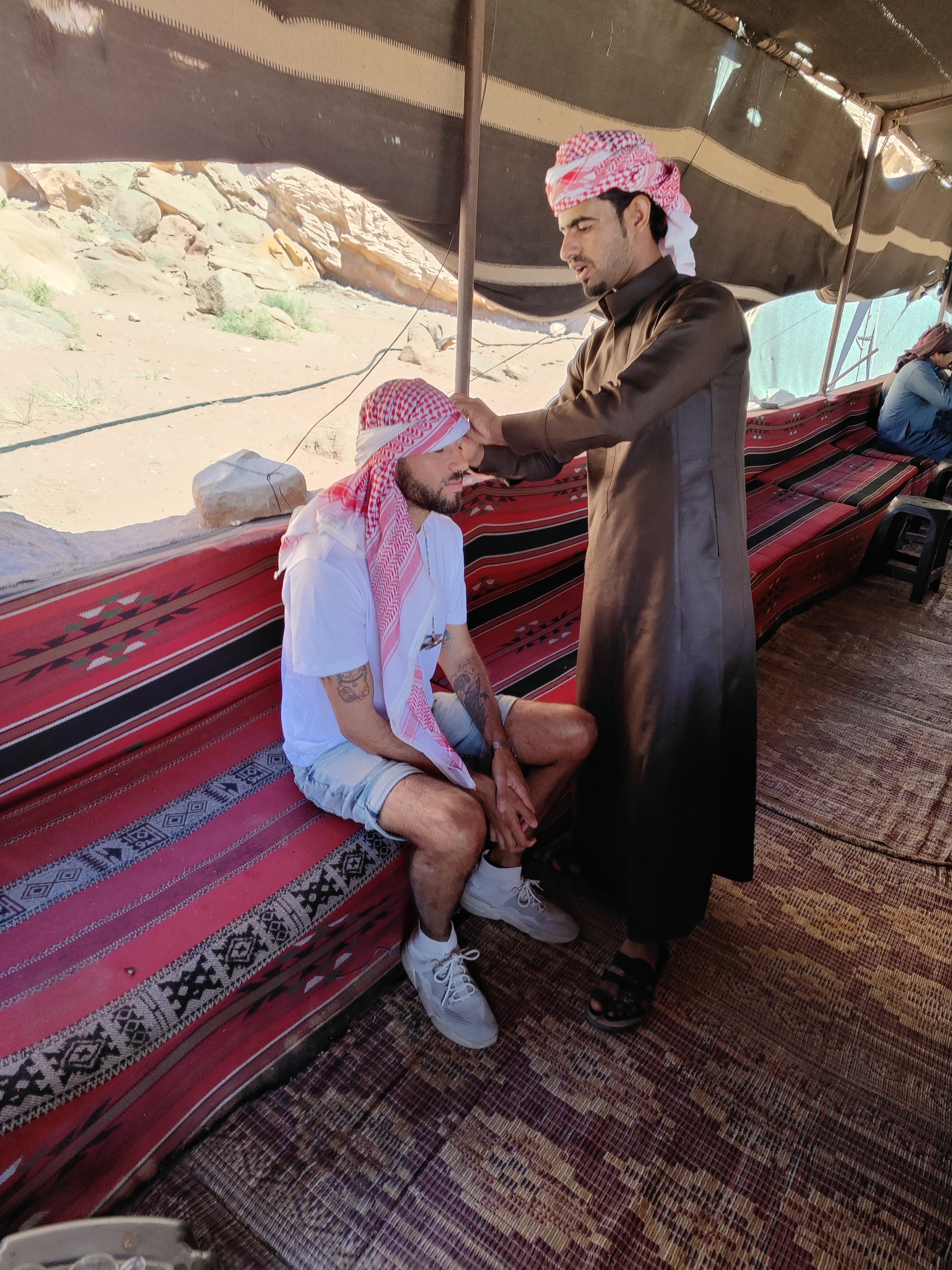 Beduino colocándonos y enseñándonos a colocar el pañuelo tradicional, llamado Shemagh jordano. Desierto de Wadi Rum, Jordania.