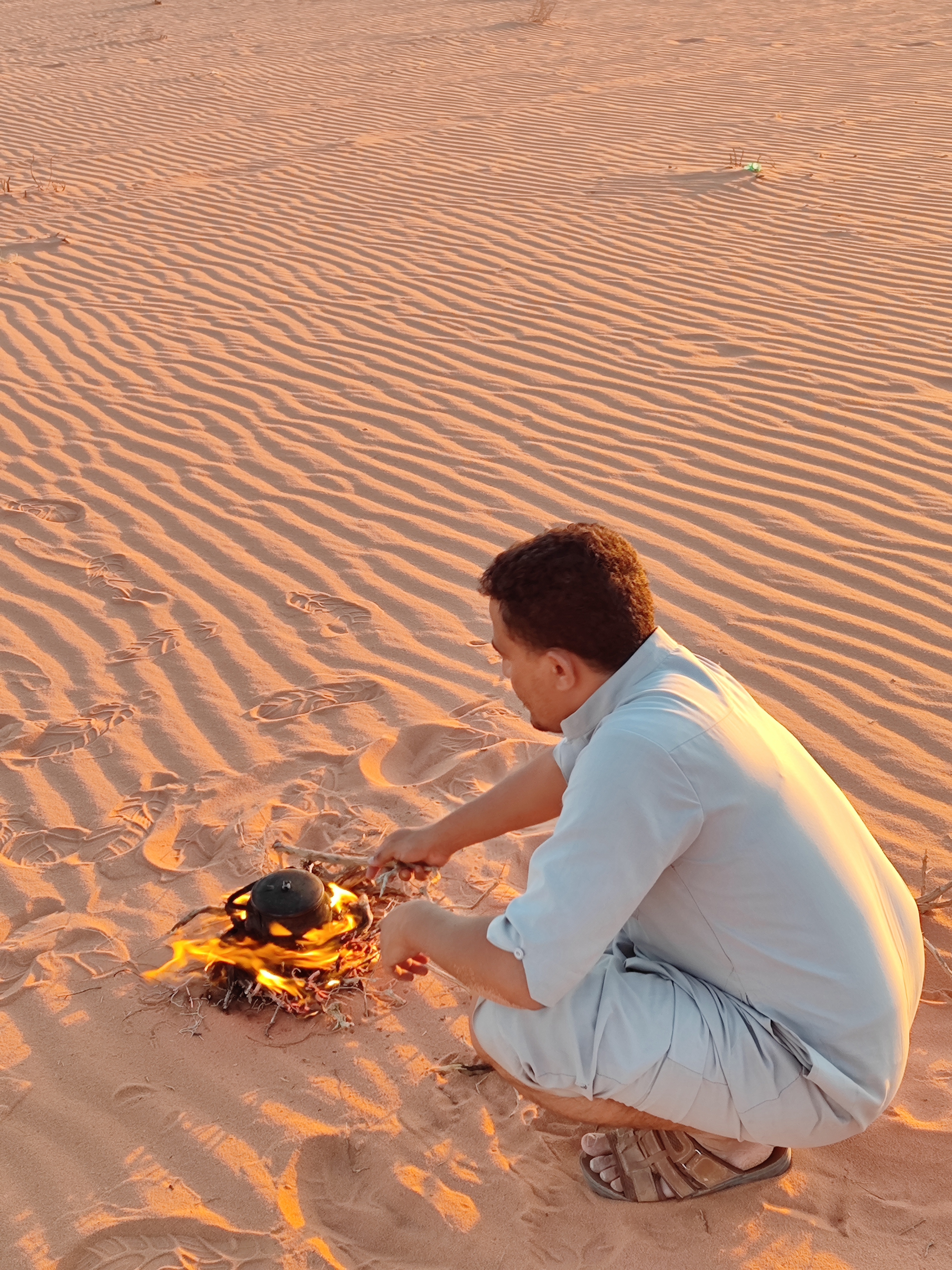 Hoguera y tetera al atardecer en el Desierto Blanco de Wadi Rum, Jordania.